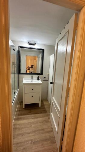 a bathroom with a sink and a mirror at Duplex Puente del rey in El Rocío