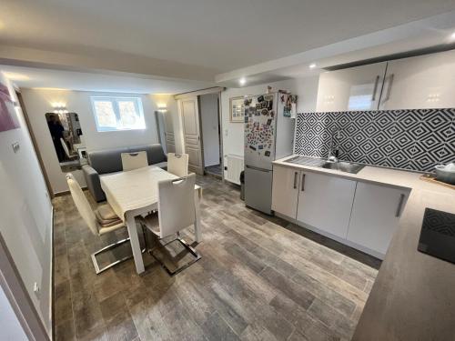 une cuisine et une salle à manger avec une table et un réfrigérateur dans l'établissement Quiet house, à Aulnay-sous-Bois