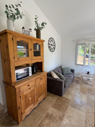 - un salon avec un canapé et un four micro-ondes dans l'établissement Maison de campagne, à Quinson