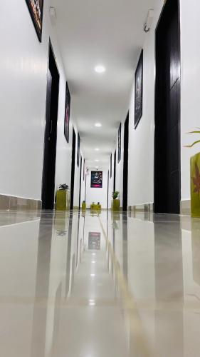 a hallway with black and white walls and a white floor at THE PLAZA, Very Close to Indira Gandhi Square, Near Sri Kamatchi Hotel, 100 feet Road, PONDICHERRY - JR Groups in Puducherry