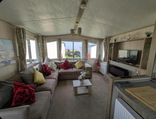 a living room with a couch and a tv at St Marys Light house, Caravan Rentals in Whitley Bay