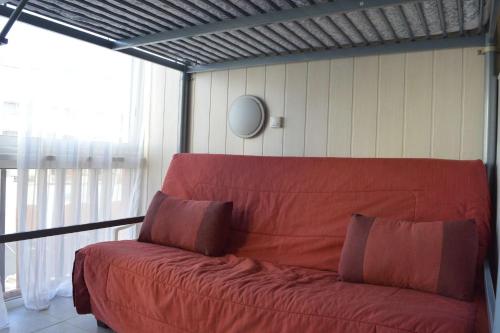 - un canapé rouge dans une chambre avec fenêtre dans l'établissement Appt Studio 4 couchages - CAP D'AGDE CT090-292, au Cap d'Agde