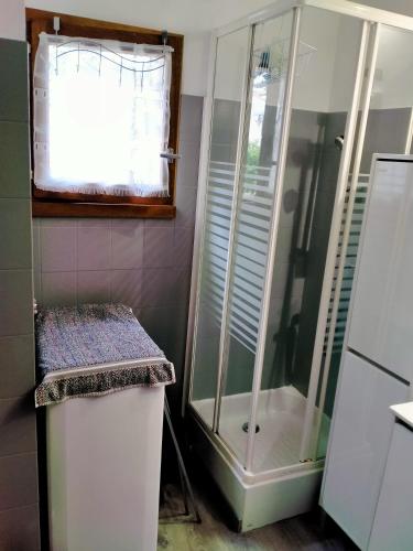 La salle de bains est pourvue d'une douche en verre et d'une fenêtre. dans l'établissement T2 35 m2 st jean centre, à Saint-Jean-de-Monts