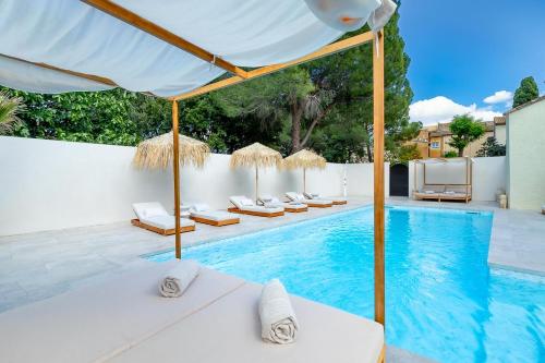 - une piscine avec des chaises longues et des parasols à côté de la piscine dans l'établissement Le Chai n°9, demeure et gîtes de charme, à Montblanc