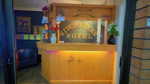 a bar with a sign that reads the entrance to a happiest motel at Winchester Motel in Moree