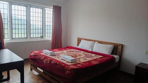 a bedroom with a bed with two towels on it at Mystical Medows in Ooty