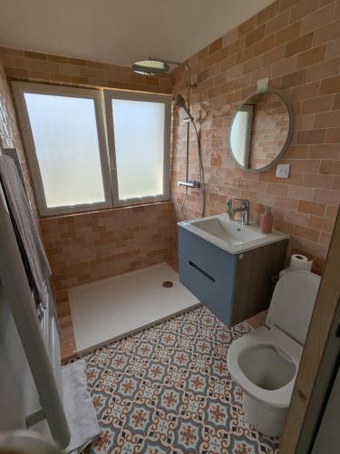 une salle de bain avec un lavabo, des toilettes et un miroir dans l'établissement Jolie appartement coeur de Vannes, à Vannes