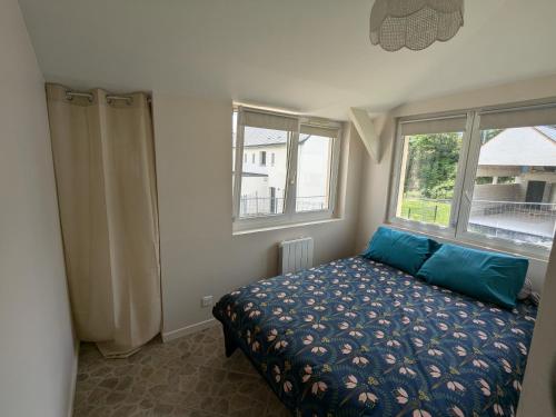 une chambre avec un lit avec des oreillers bleus et une fenêtre dans l'établissement Jolie appartement coeur de Vannes, à Vannes