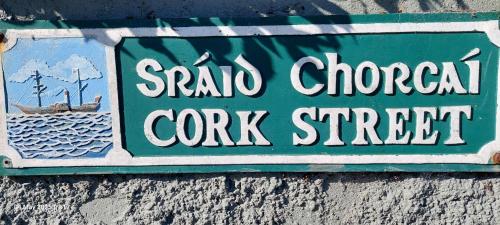 a sign for a crock street on a wall at Baxters Bonnie Garden in Passage West