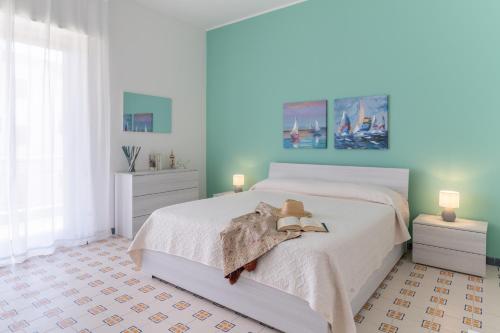 a bedroom with a white bed with a teddy bear on it at siciliacasevacanze - Marina Domus 35 in Marina di Ragusa