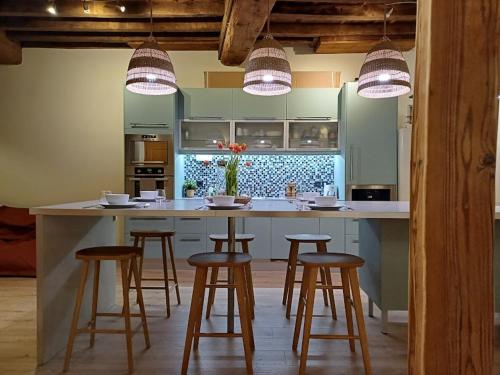 - une cuisine avec un îlot doté de tabourets de bar dans l'établissement L'Appartement Pasteur, à Chalon-sur-Saône