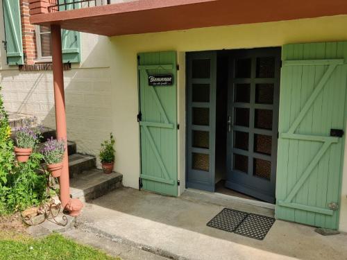 a pair of green doors in a house at Chambres d'hôtes / B&B Chez Mon Rêve in Éguzon-Chantôme