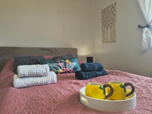 a bed with two mugs and towels on it at DOM w JESIONACH Brajniki - działka 1 HEKTAR in Jedwabno