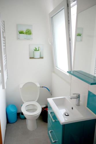 a bathroom with a toilet and a sink at Maison tout confort 6 personnes à 300m de la plage - Clim & Wifi in Mimizan-Plage