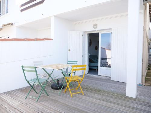 un patio avec une table et des chaises sur une terrasse dans l'établissement Appartements des Launes, à Saintes-Maries-de-la-Mer