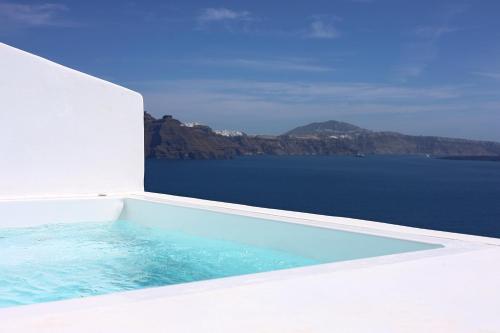 a swimming pool with a view of the ocean at Phaos Oia Suites in Oia