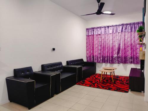 a waiting room with black chairs and a table at Serene Homestay in Tawau