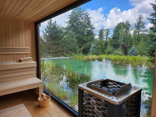 a room with a view of a lake through a window at Villa Romana Mazury in Jeziorowskie