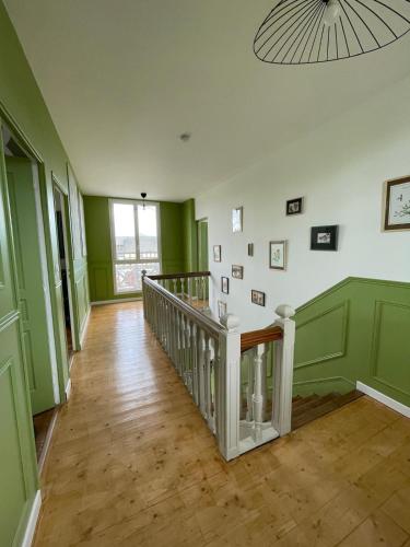 a hallway with green and white walls and a staircase at Le Clos de Lignières, chez Marguerite in Lignières-Châtelain