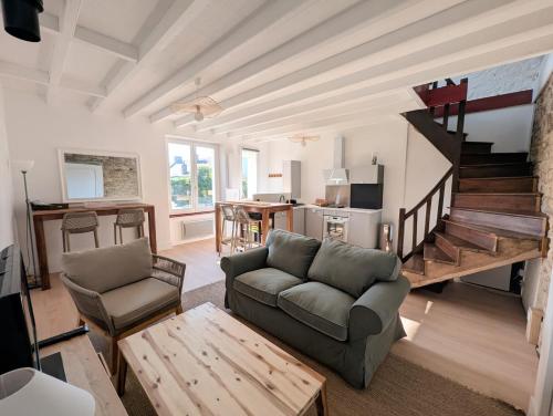 un salon avec un canapé et un escalier dans l'établissement VIEUX PASSAGE, Maison avec cour privée à 150 m du PORT et de la PLAGE, à Plouhinec