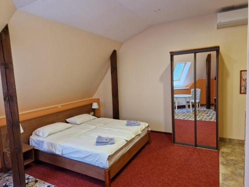 a small bedroom with a bed and a mirror at Avanta in Liepāja