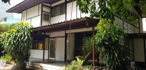 a white house with trees in front of it at AT ASok Vintage House Near BTS Asok MRT Sukhumvit in Klong Toi
