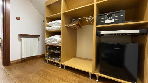 a walk in closet with wooden shelves and a refrigerator at Villa Romana Mazury in Jeziorowskie