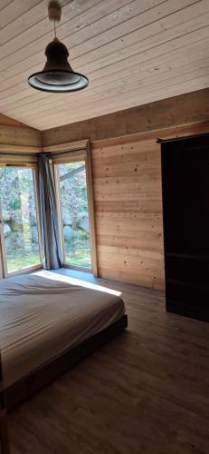 ein Schlafzimmer mit einem Bett in einem Zimmer mit einem Fenster in der Unterkunft Chalet au calme in La Bresse