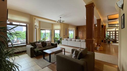 a living room with couches and a table at Villa Romana Mazury in Jeziorowskie