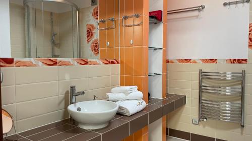 a bathroom with a sink and a mirror and towels at Villa Romana Mazury in Jeziorowskie