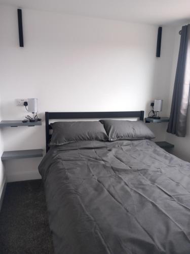 a bedroom with a large bed with two lamps on it at H21 holiday let in Mablethorpe