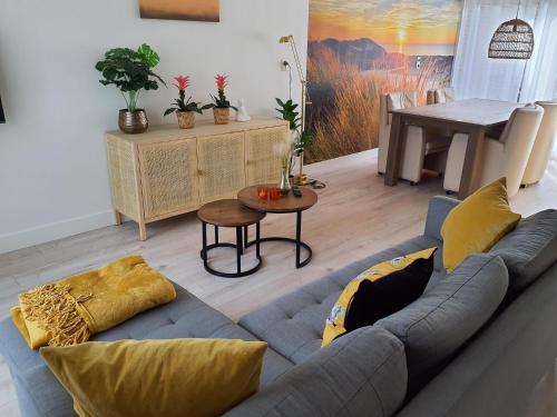 a living room with a couch and a table at Holiday house Happy House - 2 km from the beach in Noordwijkerhout