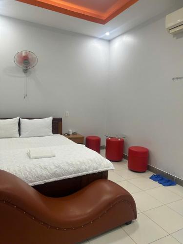 a bedroom with a bed with a brown leather seat at Nhà nghỉ Anh Vân in Ấp Thành