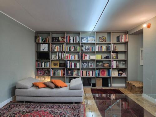 a living room with a couch and a book shelf at Un alloggio incantevole sul Lago Maggiore in Oggebbio