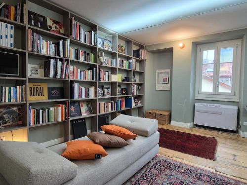 a living room with a couch and a book shelf at Un alloggio incantevole sul Lago Maggiore in Oggebbio