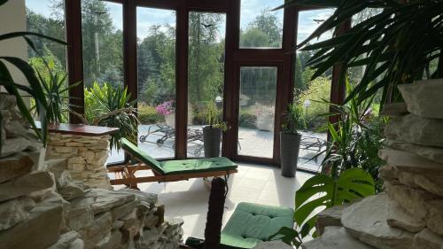 a room with a window and a bench and some plants at Villa Romana Mazury in Jeziorowskie