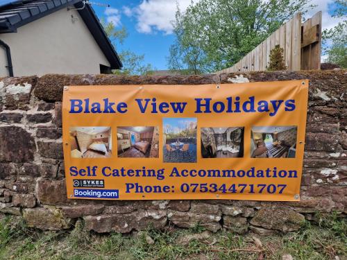 a sign for a self catering association on a stone wall at The Burrow by Blake View Holidays a peaceful boutique retreat 3 miles from Ennerdale- standard twin or super-king bed available in Rowrah