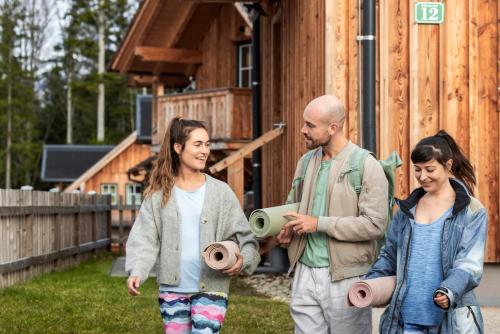 a group of three people walking in front of a building at Narzissendorf Zloam Hotel in Grundlsee