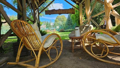 a group of rocking chairs and a table at Villa Romana Mazury in Jeziorowskie