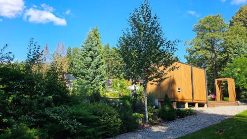 a wooden house in the middle of a garden at Villa Romana Mazury in Jeziorowskie
