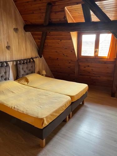 - une chambre avec 2 lits dans une cabane en bois dans l'établissement Chambre maison vigneronne - Val du Patre, à Orschwihr