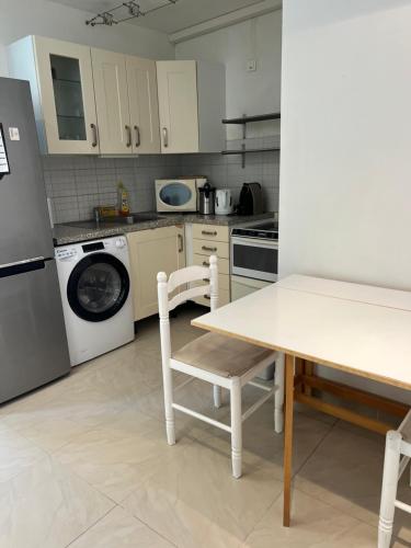une cuisine avec une table et une machine à laver dans l'établissement Villa Club PHŒNIX, à Bandol