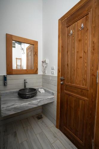 a bathroom with a sink and a wooden door at Azad Siwa Hotel in Siwa