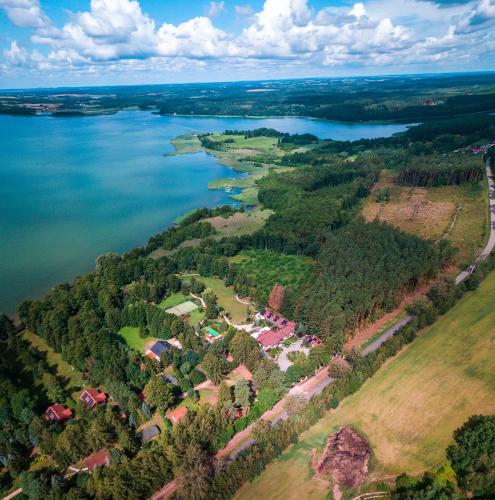 an aerial view of a house next to a lake at Villa Romana Mazury in Jeziorowskie