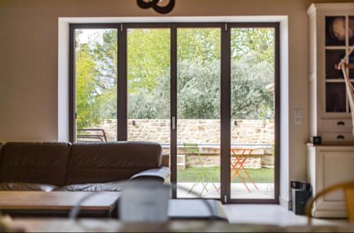 a living room with a couch and a sliding glass door at Coudignac 1891 in Lagnes