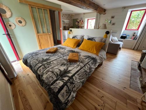 a bedroom with a large bed with yellow pillows at Maison à la campagne Les Oliviers in La Bruffière