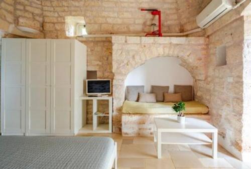 a bedroom with a bed in a stone wall at VILLA DOMINIQUE relax a pochi kilometri dal mare in Carovigno