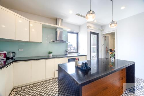 a kitchen with a black counter top in a room at Paradise Hotel & Apartment Âu Cơ - Tay Ho Lake in Hanoi