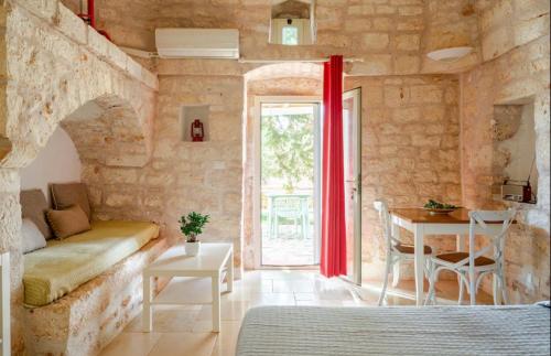 a room with a couch and a table and a window at VILLA DOMINIQUE relax a pochi kilometri dal mare in Carovigno