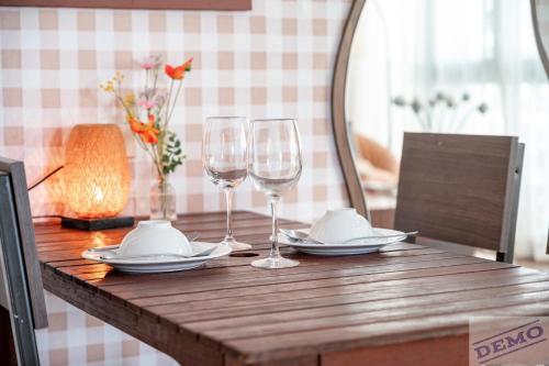 a table with two wine glasses and plates on it at Paradise Hotel & Apartment Âu Cơ - Tay Ho Lake in Hanoi